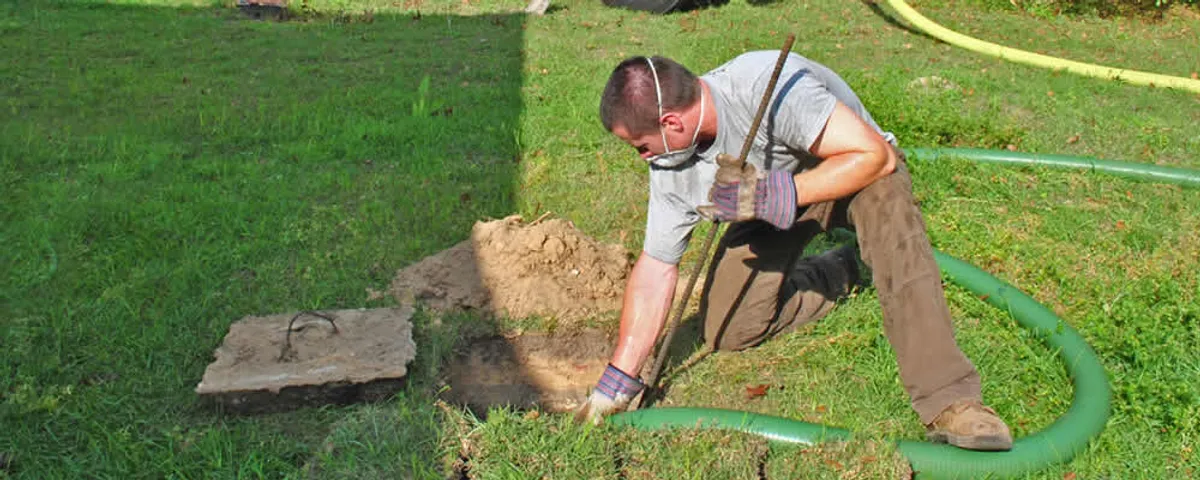 Septic pumping technician servicing a residential septic tank in Fort Collins, CO